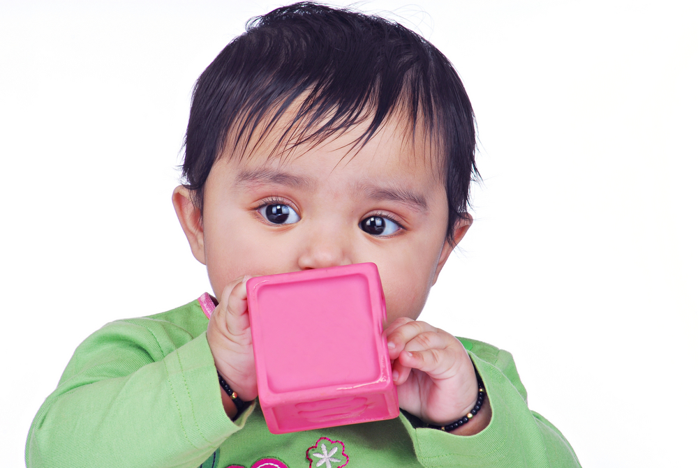 Kid putting toy in his mouth.